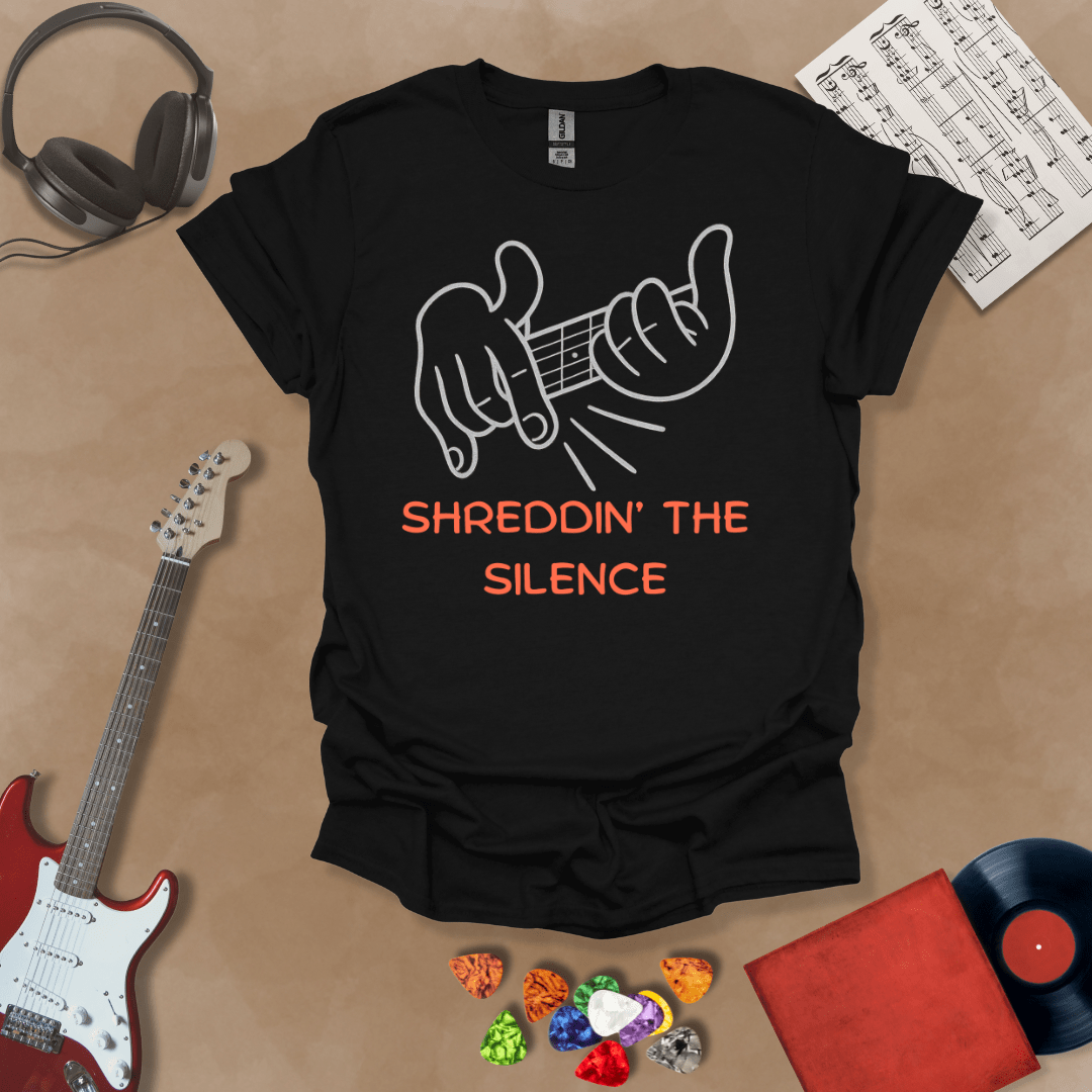 Black t-shirt featuring cartoon-style hands shredding a guitar riff with the text “Shreddin’ the Silence” in bold orange letters.