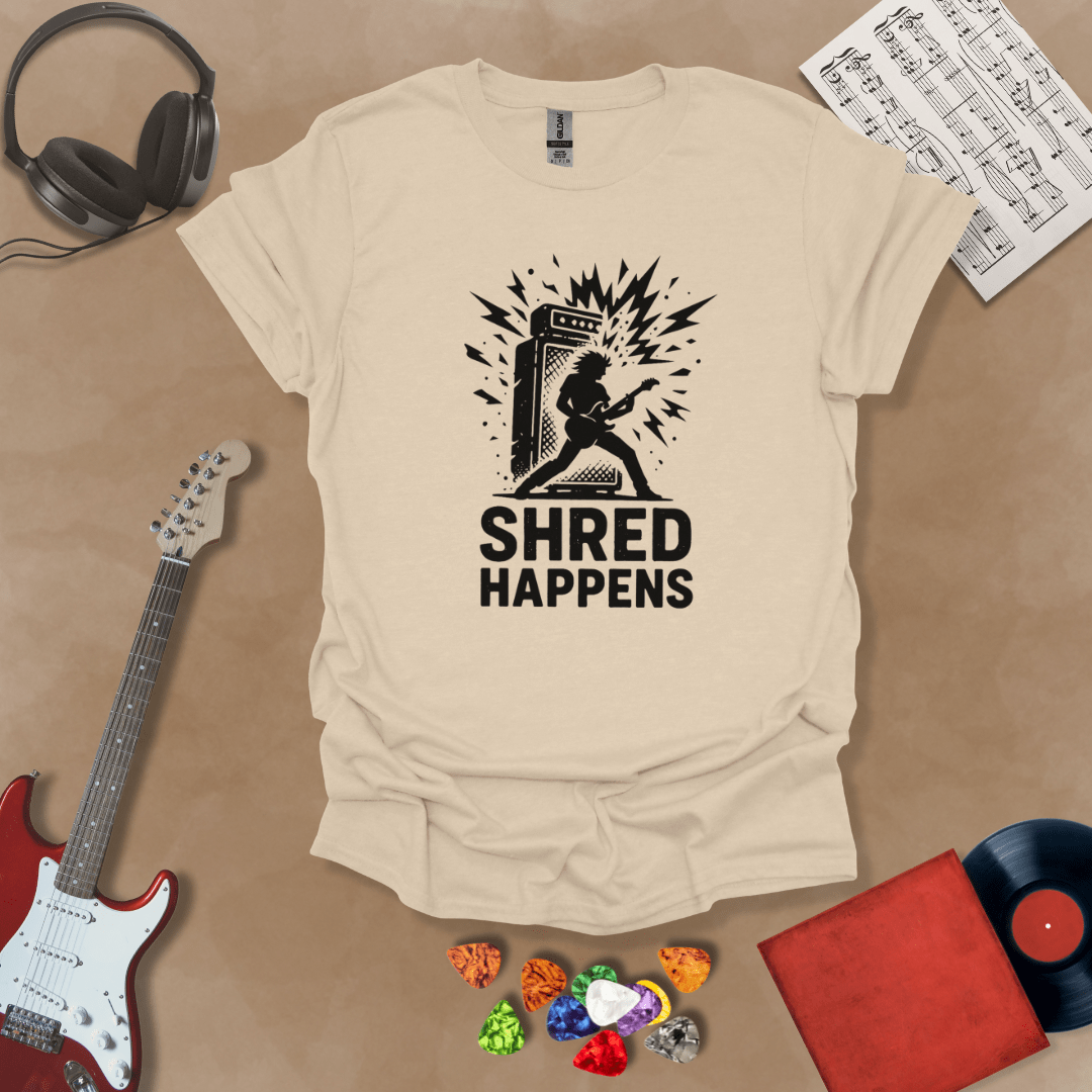 Beige t-shirt with Guitarist shredding in front of amp with text 'Shred Happens'