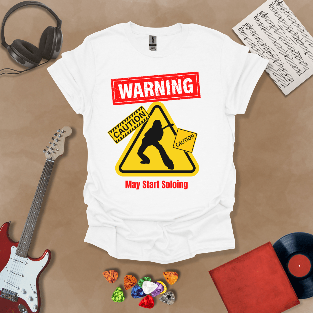 White t-shirt with bold red “Warning” text, yellow caution triangle with guitarist silhouette, text “May Start Soloing.”