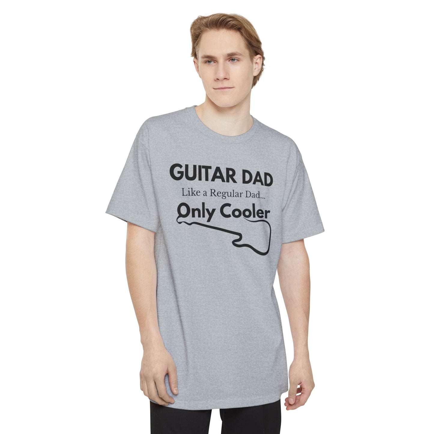 A male wearing a light gray Guitar Dad Signature Edition Tall Fit t-shirt featuring a light beige guitar-inspired graphic on the front with integrated typography, designed with extra length for a comfortable fit.