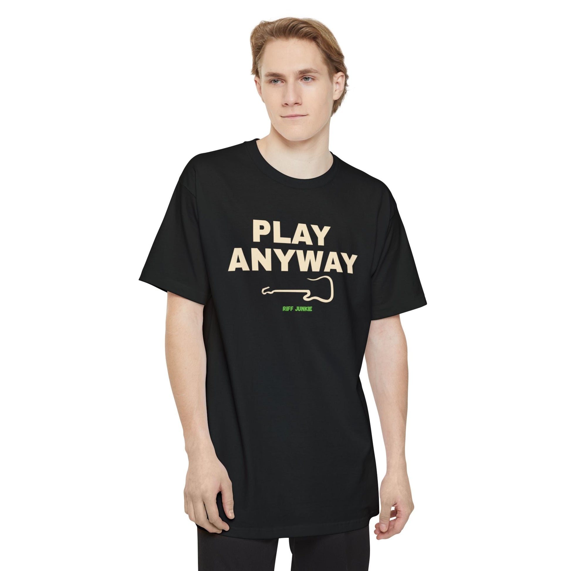 A man wearing a black short-sleeve t-shirt with a graphic on the chest that reads 'PLAY ANYWAY' in beige block letters above a beige guitar outline and small green 'Riff Junkie' text, shown on a plain white background.