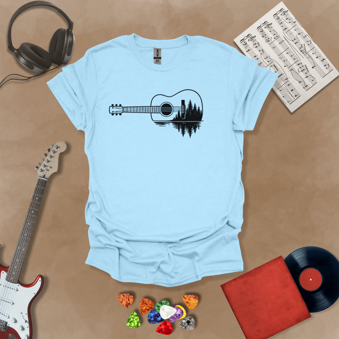 Light blue t-shirt with a black graphic of an acoustic guitar, featuring a reflection of pine trees and water inside the guitar body.