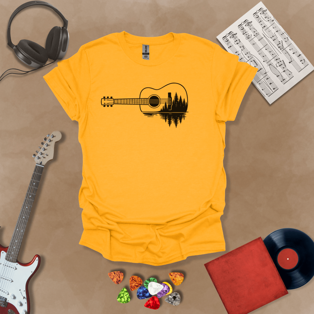 Gold t-shirt with a black graphic of an acoustic guitar, featuring a reflection of pine trees and water inside the guitar body.