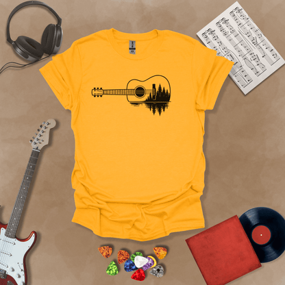Gold t-shirt with a black graphic of an acoustic guitar, featuring a reflection of pine trees and water inside the guitar body.