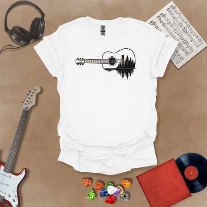 White t-shirt with a black graphic of an acoustic guitar, featuring a reflection of pine trees and water inside the guitar body.