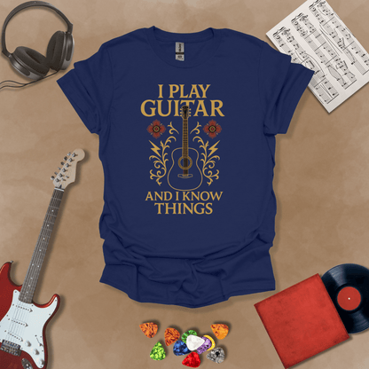 Navy t-shirt with bold medieval-inspired graphic and text “I Play Guitar and I Know Things,” blending rock style with witty humor by Riff Junkie.