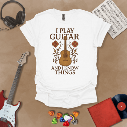 White  t-shirt with bold medieval-inspired graphic and text “I Play Guitar and I Know Things,” blending rock style with witty humor by Riff Junkie.