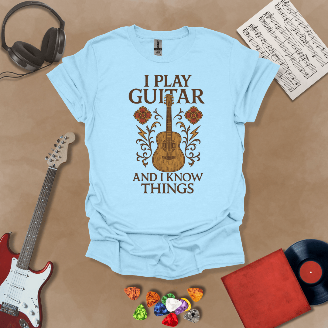 Blue t-shirt with bold medieval-inspired graphic and text “I Play Guitar and I Know Things,” blending rock style with witty humor by Riff Junkie.