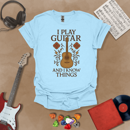 Blue t-shirt with bold medieval-inspired graphic and text “I Play Guitar and I Know Things,” blending rock style with witty humor by Riff Junkie.
