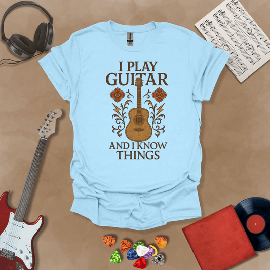 Blue t-shirt with bold medieval-inspired graphic and text “I Play Guitar and I Know Things,” blending rock style with witty humor by Riff Junkie.