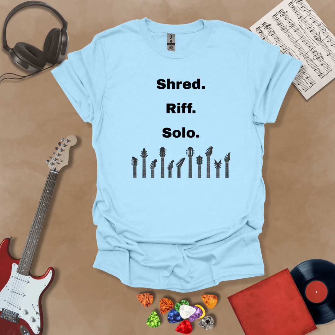 Light blue T-shirt with text 'Shred. Riff. Solo.' with row of guitar headstocks silhouette
