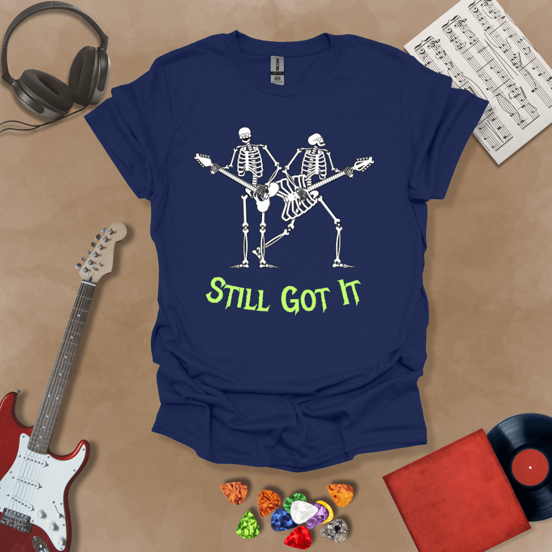 Blue Vintage style t-shirt with Two skeletons playing guitars, text 'Still Got It' with bold retro lettering and rock vibe on a transparent background.