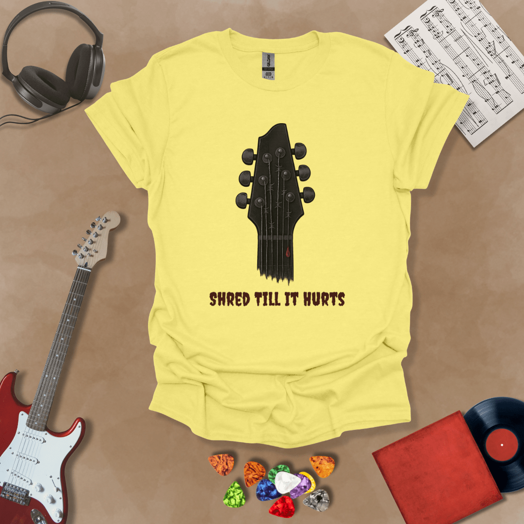 Yellow t-shirt with distressed guitar graphic, text “Shred ’Til It Hurts.”