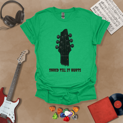 Green t-shirt with distressed guitar graphic, text “Shred ’Til It Hurts.”