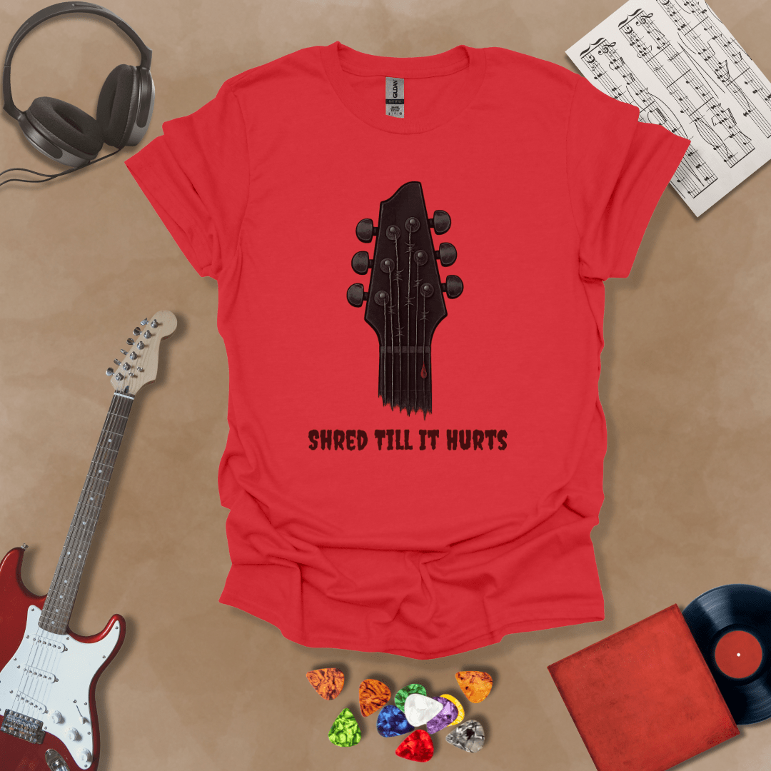 Red t-shirt with distressed guitar graphic, text “Shred ’Til It Hurts.”