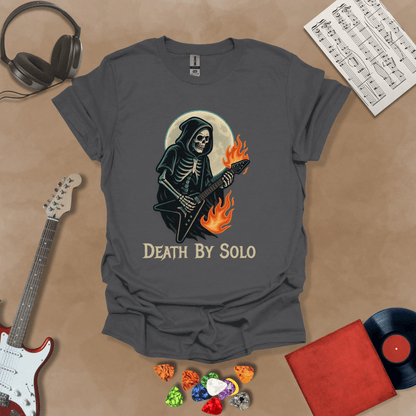 Gray t-shirt with a graphic of a grim reaper skeleton playing a flaming V-style guitar under a glowing full moon, with the text “Death By Solo” below.
