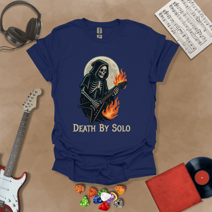 Navy t-shirt with a graphic of a grim reaper skeleton playing a flaming V-style guitar under a glowing full moon, with the text “Death By Solo” below.
