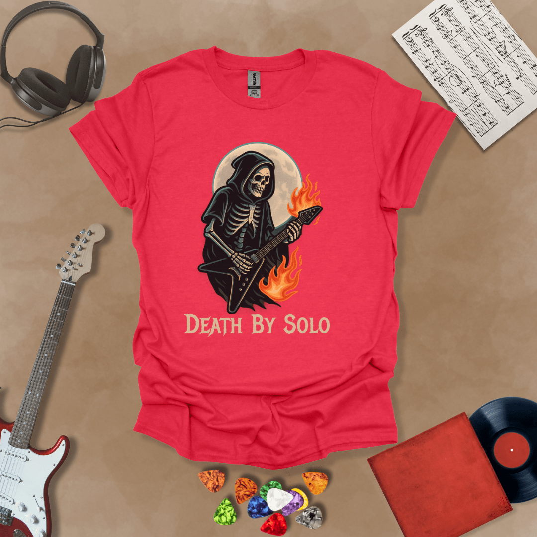 Red t-shirt with a graphic of a grim reaper skeleton playing a flaming V-style guitar under a glowing full moon, with the text “Death By Solo” below.
