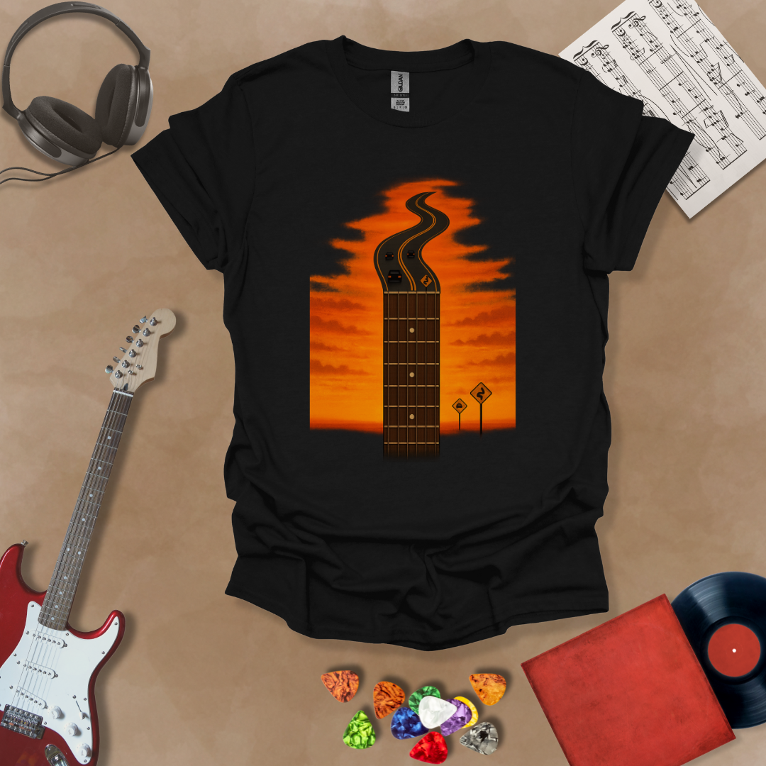 Black t-shirt with long guitar neck blending into a road under sunset sky.
