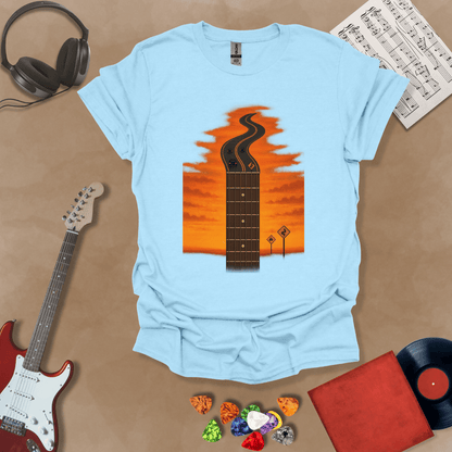 Light blue t-shirt with long guitar neck blending into a road under sunset sky.
