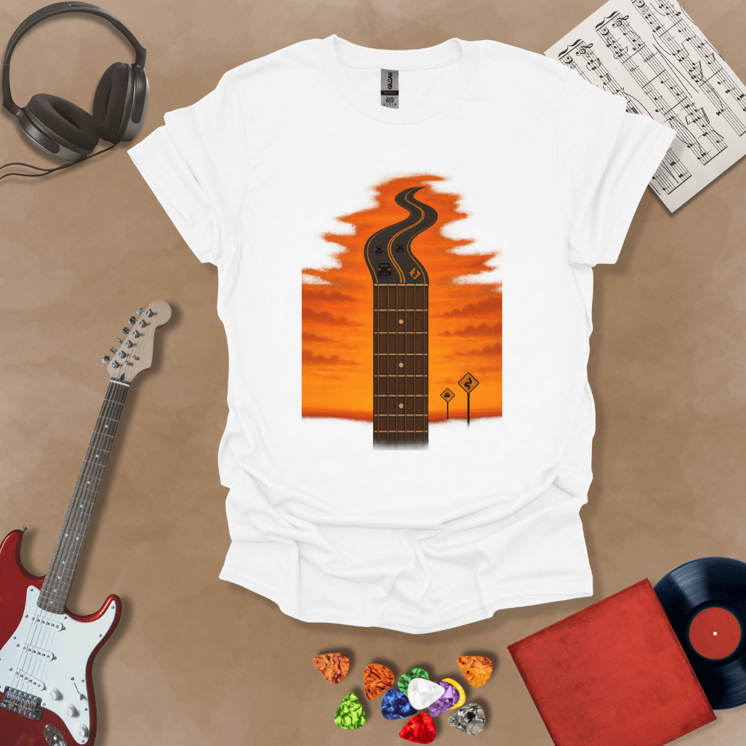 White t-shirt with long guitar neck blending into a road under sunset sky.

