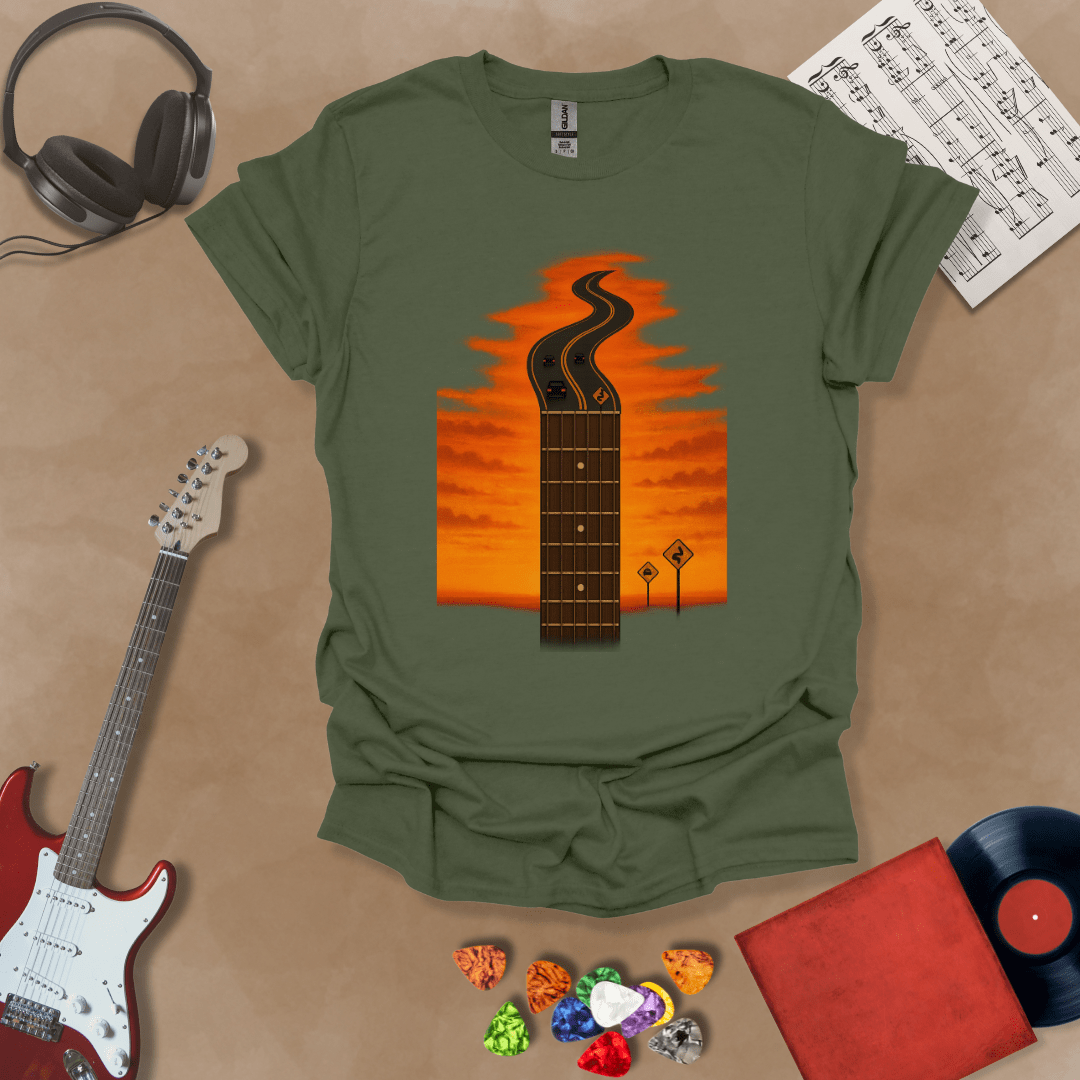 Green t-shirt with long guitar neck blending into a road under sunset sky.
