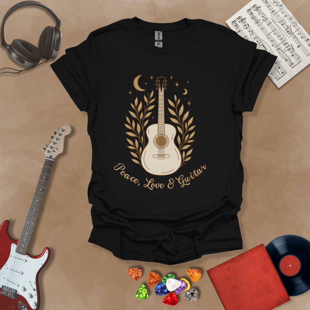 Black t-shirt featuring an acoustic guitar surrounded by leaves, moons, and stars in an earthy, bohemian line-art style, with the text “Peace, Love & Guitar” below.
