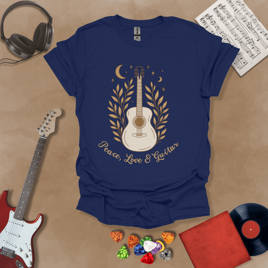 Navy t-shirt featuring an acoustic guitar surrounded by leaves, moons, and stars in an earthy, bohemian line-art style, with the text “Peace, Love & Guitar” below.
