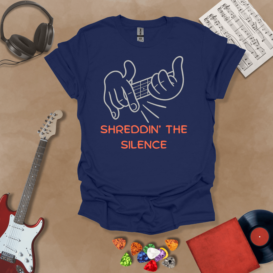 Navy t-shirt featuring cartoon-style hands shredding a guitar riff with the text “Shreddin’ the Silence” in bold orange letters.
