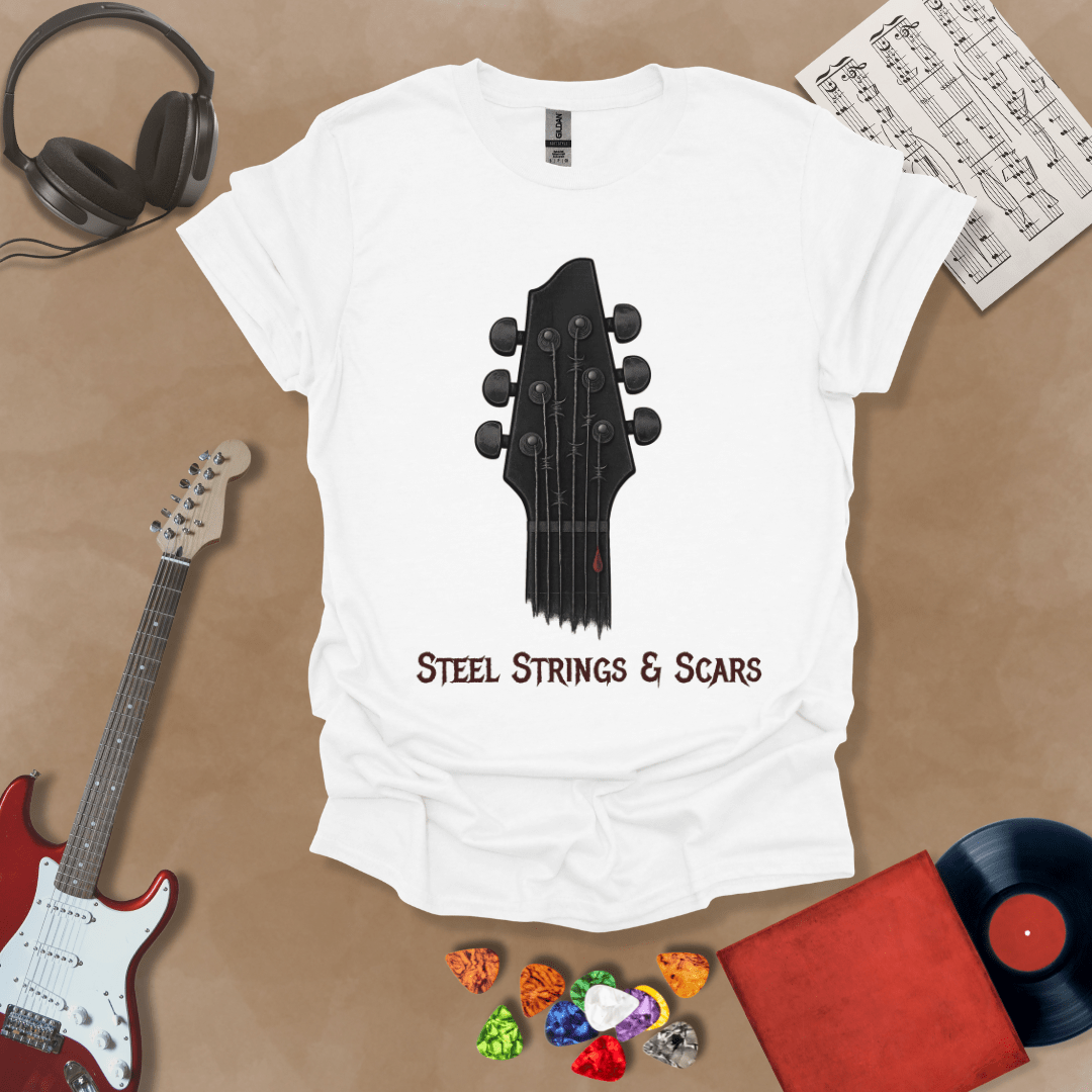 White t-shirt featuring a guitar headstock with razor-wire steel strings and a drop of blood, with the text “Steel Strings & Scars” below.
