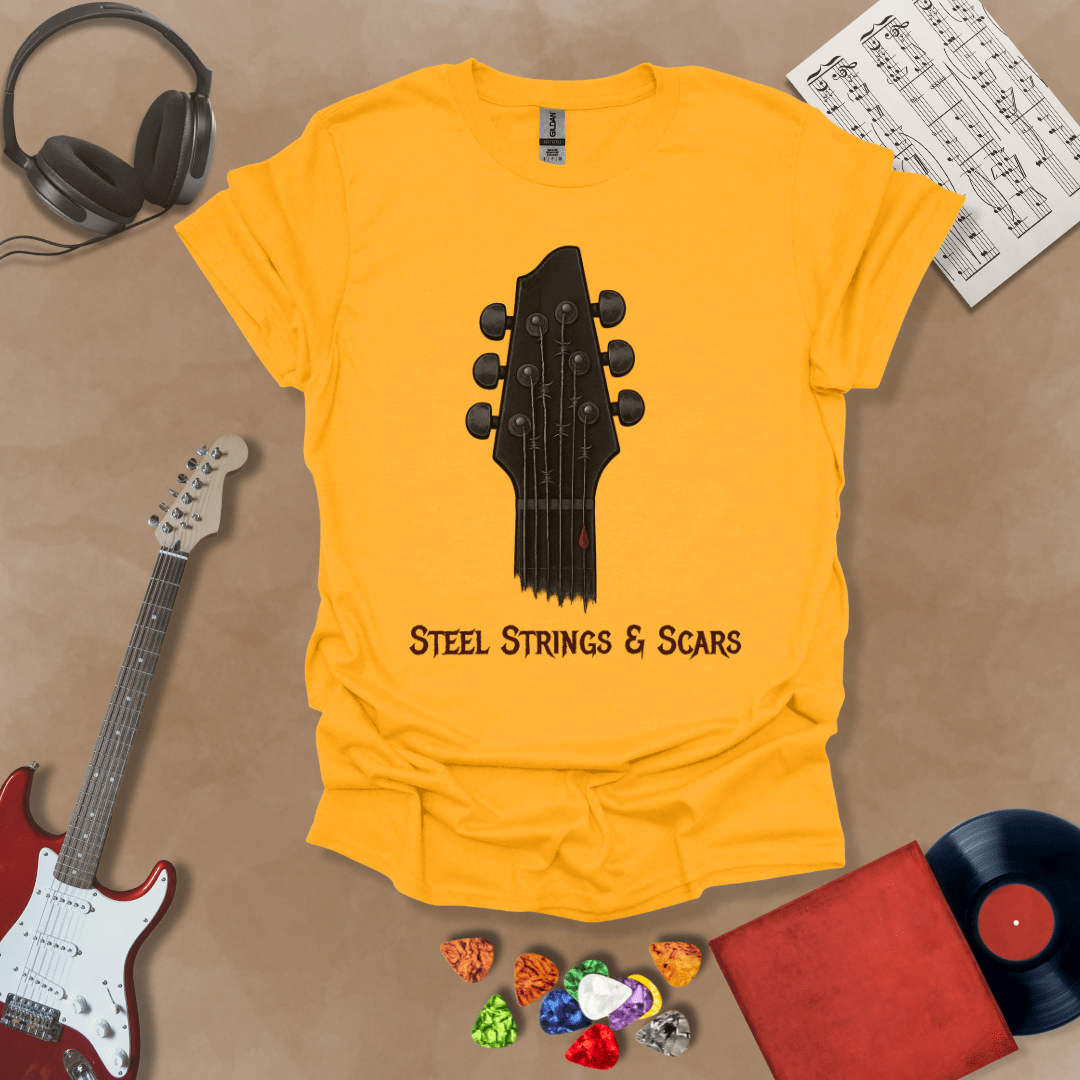 Yellow t-shirt featuring a guitar headstock with razor-wire steel strings and a drop of blood, with the text “Steel Strings & Scars” below.