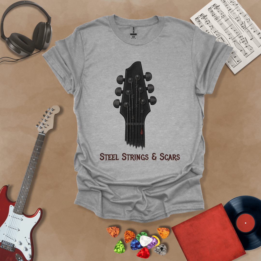 Gray t-shirt featuring a guitar headstock with razor-wire steel strings and a drop of blood, with the text “Steel Strings & Scars” below.
