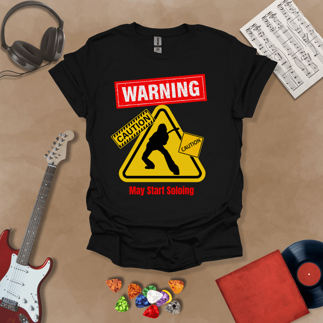 Black t-shirt with bold red “Warning” text, yellow caution triangle with guitarist silhouette, text “May Start Soloing.”
