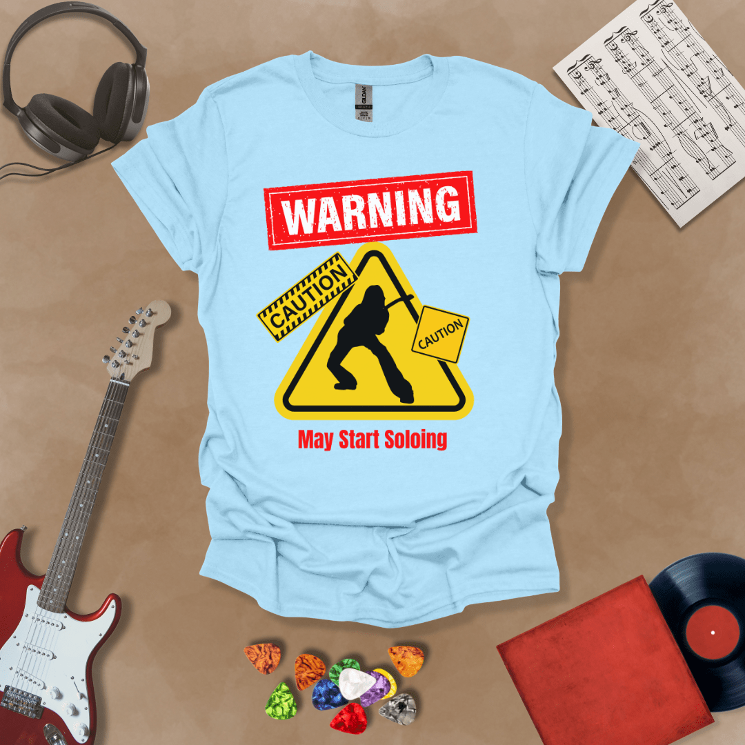 Light blue t-shirt with bold red “Warning” text, yellow caution triangle with guitarist silhouette, text “May Start Soloing.”
