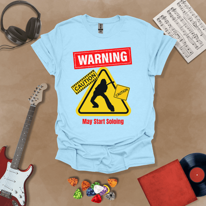 Light blue t-shirt with bold red “Warning” text, yellow caution triangle with guitarist silhouette, text “May Start Soloing.”
