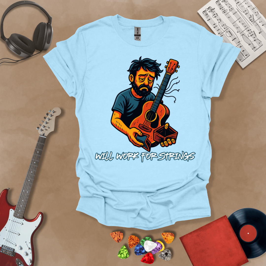 Light Blue t-shirt with a graphic of Cartoon-style illustration of a scruffy man holding a broken guitar and an empty wallet, looking sad. and text 'Will work for strings' .