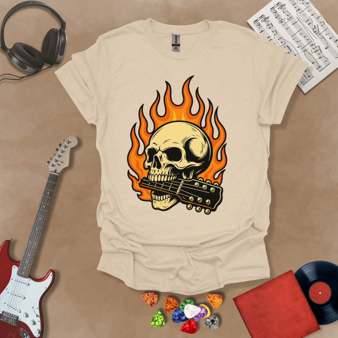 Sand t-shirt with flaming skull graphic biting a guitar neck.