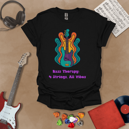 Black t-shirt with psychedelic-style bass guitar illustration, colorful wavy accents, text “Bass Therapy: 4 Strings, All Vibes