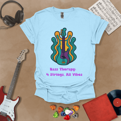 Light blue t-shirt with psychedelic-style bass guitar illustration, colorful wavy accents, text “Bass Therapy: 4 Strings, All Vibes