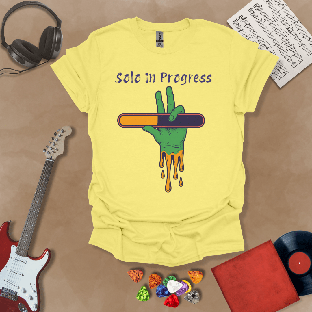 Cornsilk t-shirt with green zombie-like hand holding a colorful loading bar, text “Solo in Progress.”