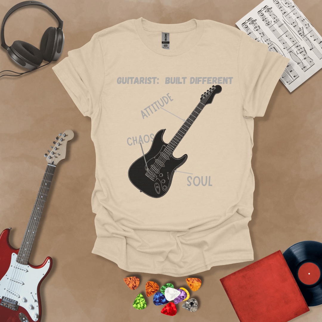 Beige t-shirt with black electric guitar diagram labeled “Attitude, Chaos, Soul,” text “Guitarist: Built Different.”
