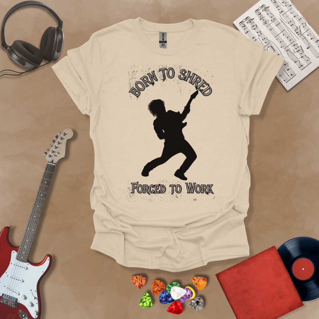 Light Blue t-shirt with Silhouette of a guitarist rocking out with glowing accents, framed by the text 'Born to Shred, Forced to Work' in bold distressed lettering.