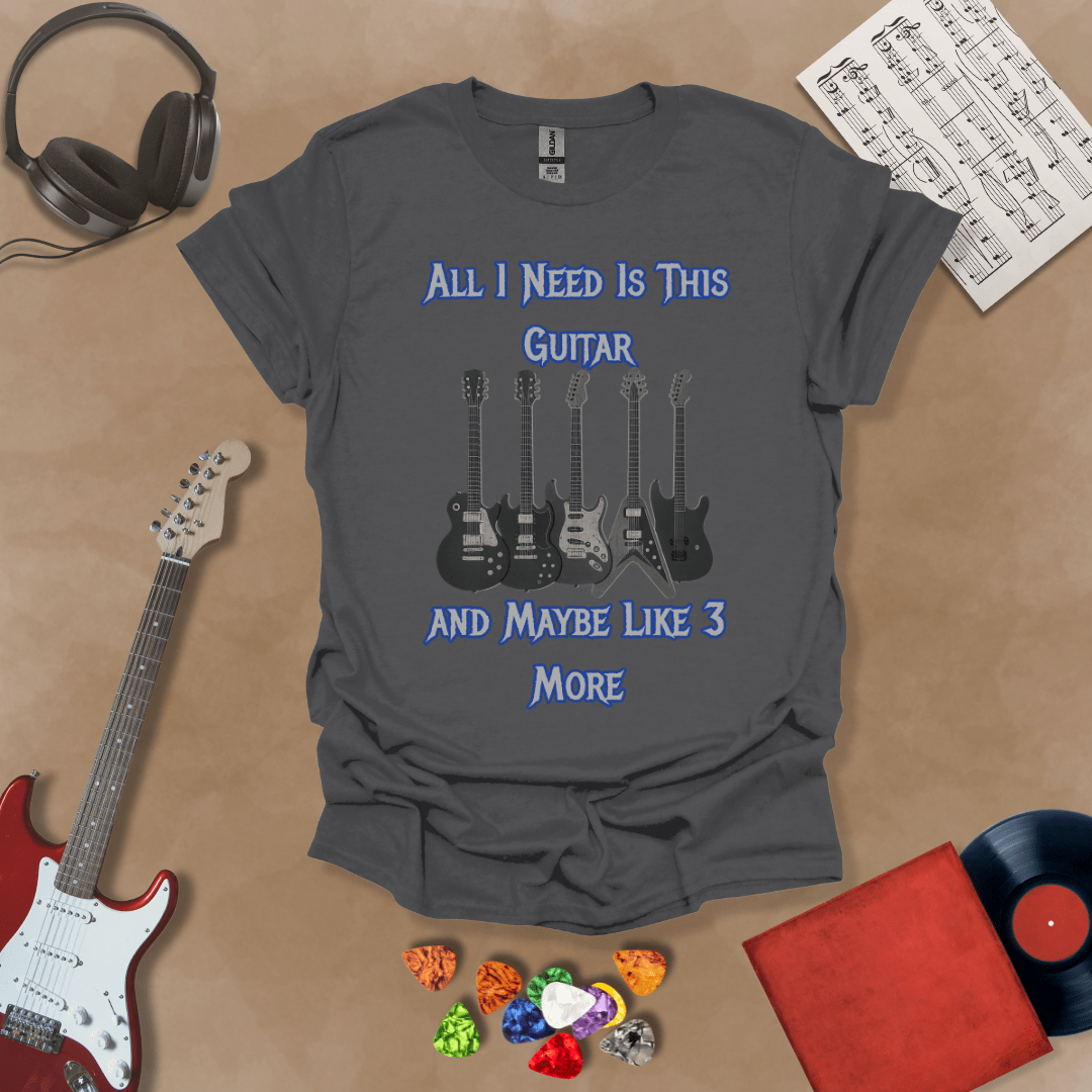 Gray t-shirt with Row of five electric guitars under bold blue text reading ‘All I Need Is This Guitar and Maybe Like 3 More,’ rock-inspired graphic t-shirt design