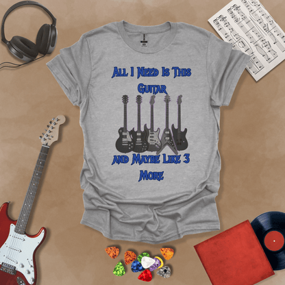 Gray t-shirt with Row of five electric guitars with neon glow accents under bold blue text reading ‘All I Need Is This Guitar and Maybe Like 3 More,’ rock-inspired graphic t-shirt design