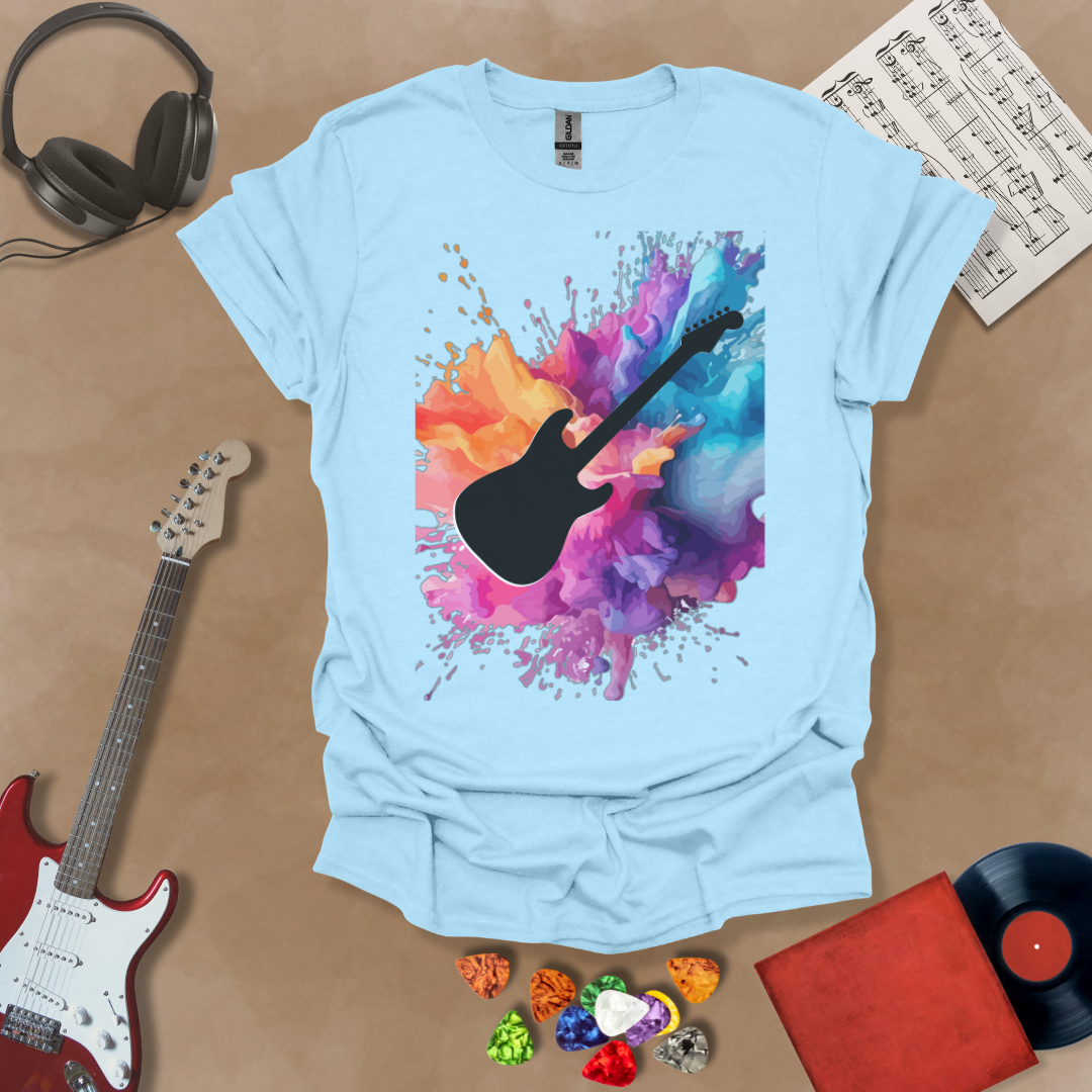 Light blue t-shirt with Black electric guitar silhouette bursting through vibrant paint splash explosion in orange, pink, purple, and blue, abstract art tee design.
