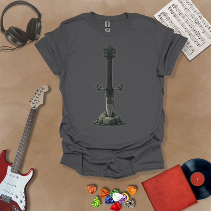 Gray t-shirt with Illustration of a battle-worn guitar sword glowing with a smoky gray aura, titled Axecalibur: Forged in Shadow, printed on a dark tee by Riff Junkie.
