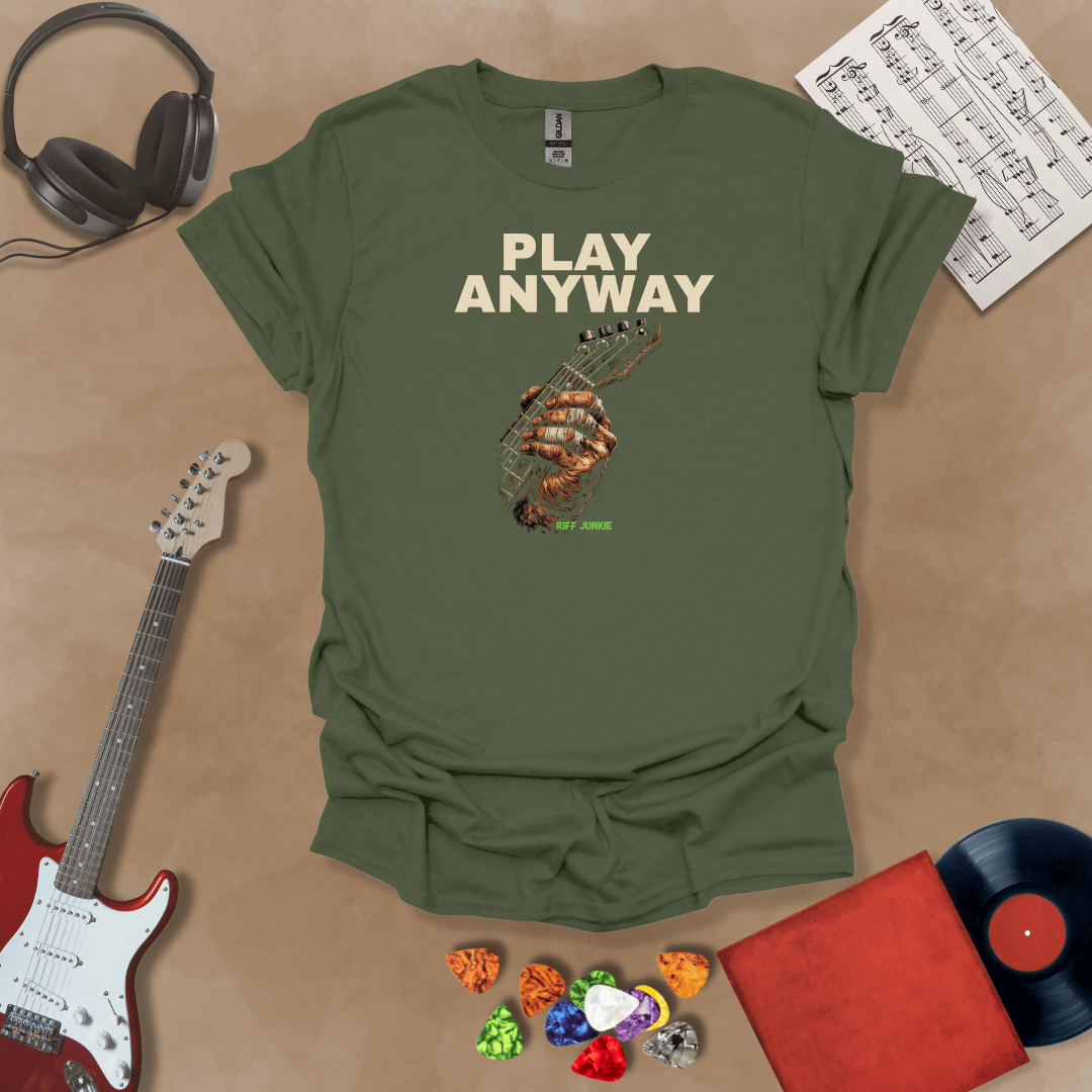 Play Anyway – Riff Edition graphic Green t-shirt featuring bold stacked text above a weathered hand gripping a guitar fretboard with taped fingers and Riff Junkie branding.