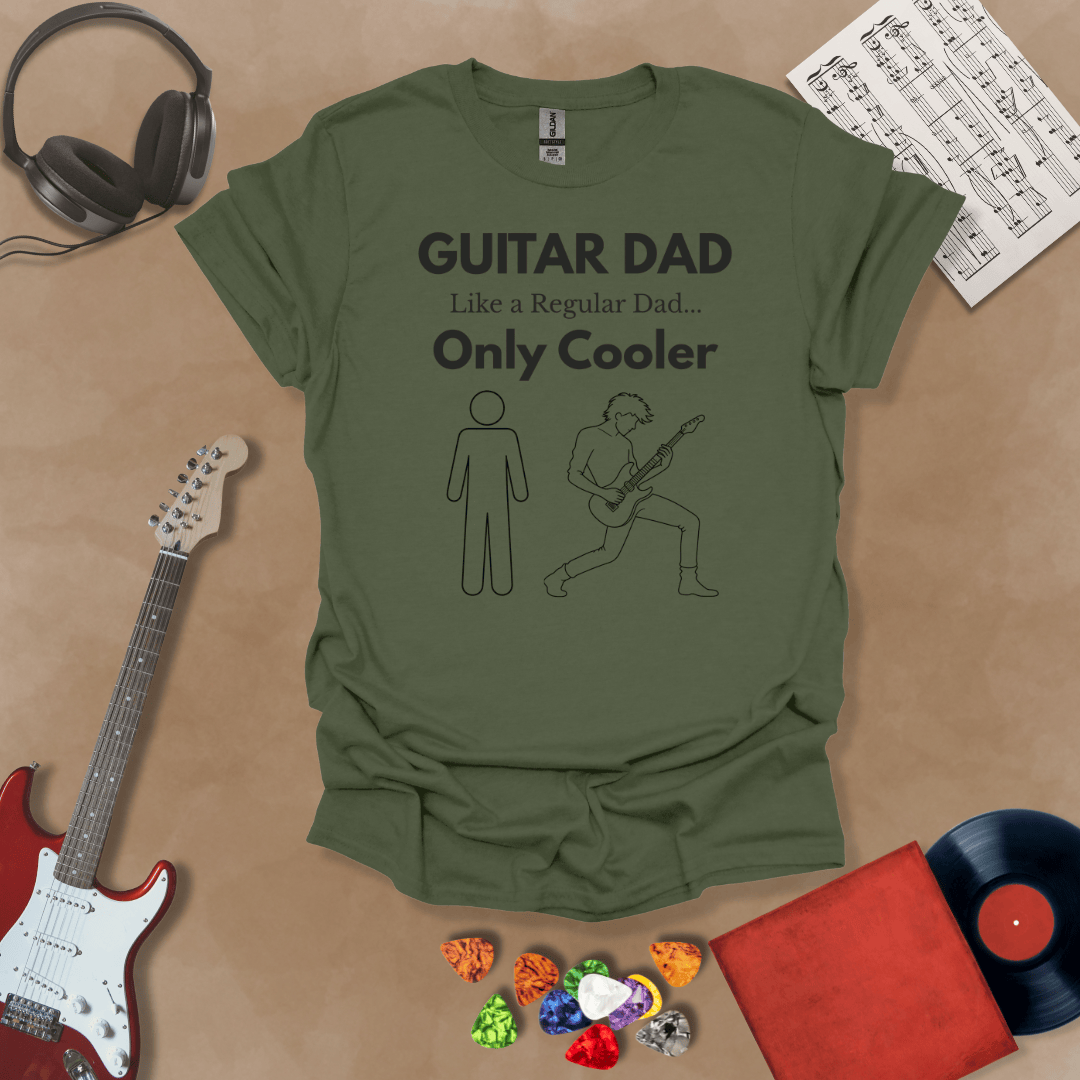 A military green Guitar Dad Sketch Edition t-shirt featuring a hand-drawn illustration of a regular dad and a rocker dad, laid flat on a tan background with guitar-themed props.
