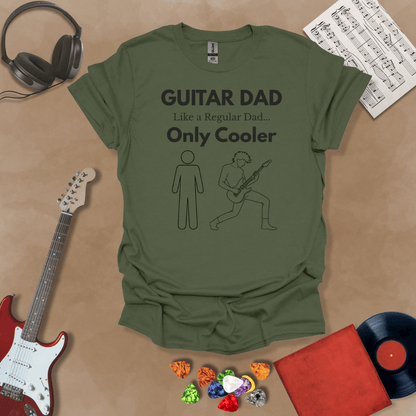 A military green Guitar Dad Sketch Edition t-shirt featuring a hand-drawn illustration of a regular dad and a rocker dad, laid flat on a tan background with guitar-themed props.