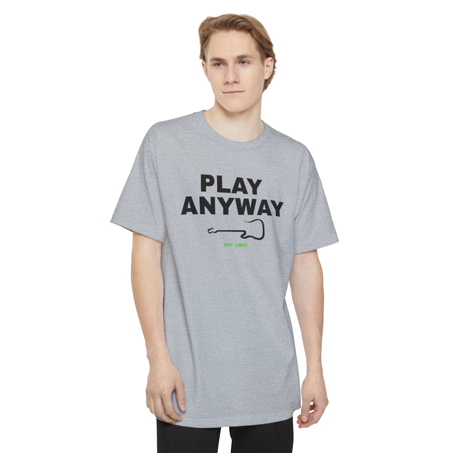 A man wearing a navy short-sleeve t-shirt with a graphic on the chest that reads 'PLAY ANYWAY' in beige block letters above a beige guitar outline and small green 'Riff Junkie' text, shown on a plain white background.